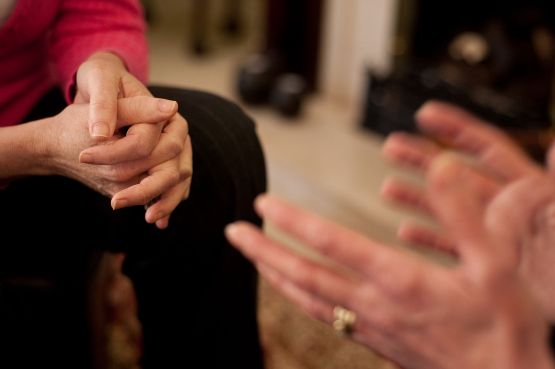 Two people talking, gesturing with their hands